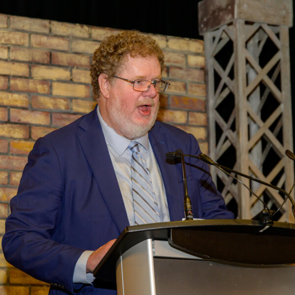 Doug Speirs, Chair of the Laughs + Libations Committee giving a speech at the 2023 Laughs + Libations Event