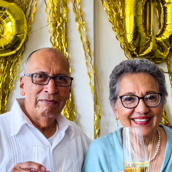 A couple sipping champagne and celebrating their 50th wedding anniversary.