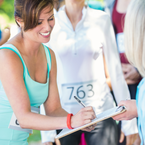 A lady signs a form before participating in a race.