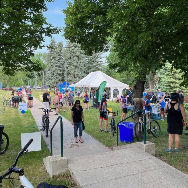 Cyclists, family and friends, standing around near the food tent after the bike rides.