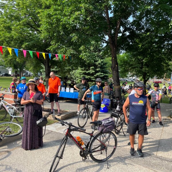 Cyclists standing around in anticipation of beginning their rides.